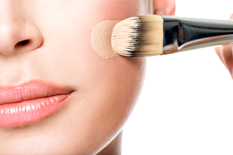 Makeup artist applying liquid tonal foundation  on the face