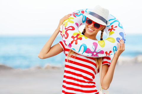 Beach woman happy and colorful wearing sunglasses and beach hat having summer fun during travel holidays vacation