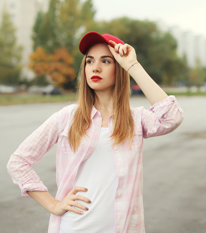 Fashion portrait pretty young girl wearing a shirt and red cap