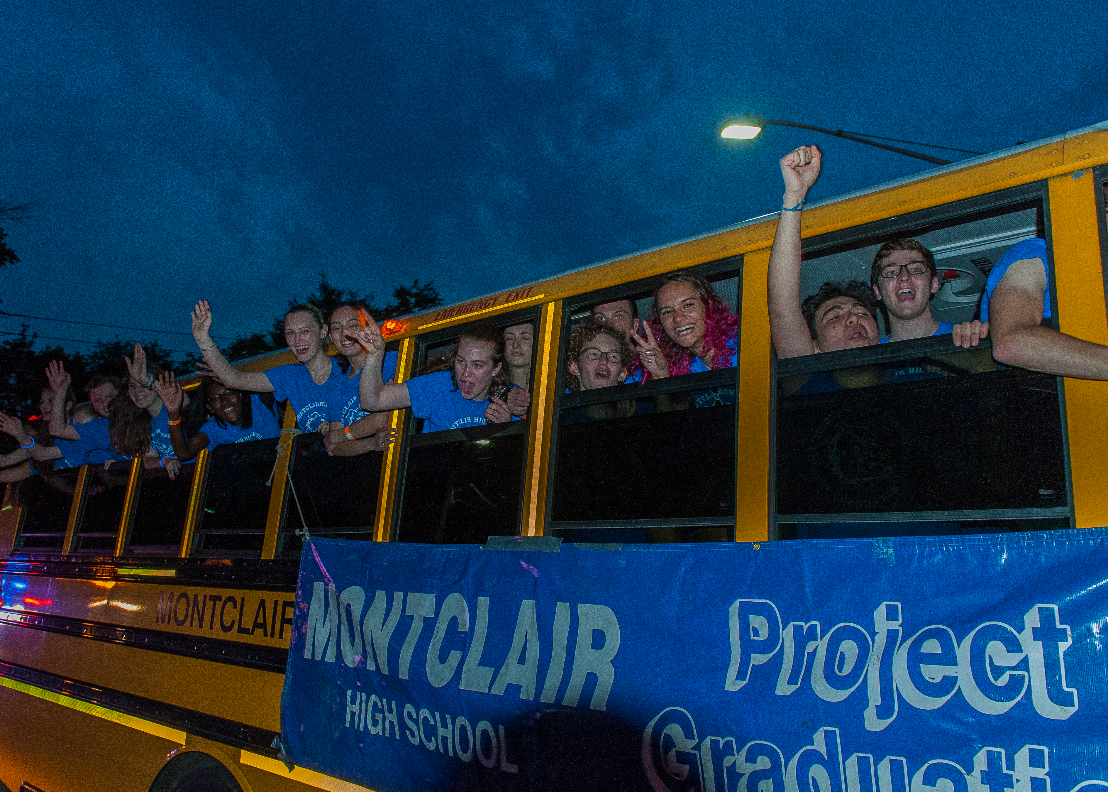 Students riding school busses through Watchung Plaza on their way to Project Graduation. Photo by Scott Kennedy for The Montclair Dispatch.